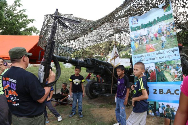 Los militares muestran su armamento a los niños.