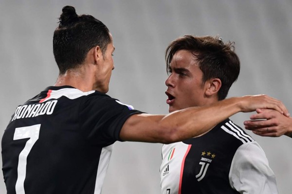 Juventus' Argentine forward Paulo Dybala (R) celebrates with Juventus' Portuguese forward Cristiano Ronaldo after opening the scoring during the Italian Serie A football match Juventus vs Lecce played on June 26, 2020 behind closed doors at the Juventus stadium in Turin, as the country eases its lockdown aimed at curbing the spread of the COVID-19 infection, caused by the novel coronavirus. (Photo by Miguel MEDINA / AFP)