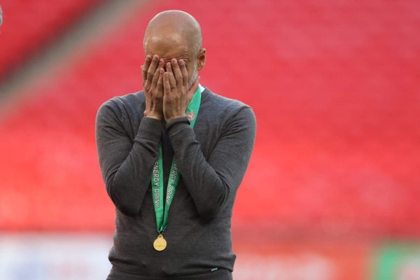 Manchester City's Spanish manager Pep Guardiola reacts whilst wearing his winners medal after the English League Cup final football match between Manchester City and Tottenham Hotspur at Wembley Stadium, northwest London on April 25, 2021. - Manchester City claimed a fourth consecutive League Cup on Sunday with a dominant display to beat Tottenham 1-0 in front of 8,000 fans at Wembley. (Photo by CARL RECINE / POOL / AFP) / RESTRICTED TO EDITORIAL USE. No use with unauthorized audio, video, data, fixture lists, club/league logos or 'live' services. Online in-match use limited to 120 images. An additional 40 images may be used in extra time. No video emulation. Social media in-match use limited to 120 images. An additional 40 images may be used in extra time. No use in betting publications, games or single club/league/player publications. /