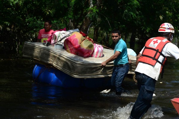 Local residents evacuate a flooded area in the municipality of Baracoa, department of Cortes, Honduras, on November 8, 2020. - Scores of people have died or remain unaccounted for as the remnants of Hurricane Eta unleashed floods and triggered landslides on its deadly march across Central America. (Photo by Orlando SIERRA / AFP)
