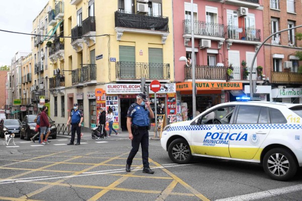 Policemen block a street at the Vallecas neighborhood in Madrid, on September 20, 2020, during a demonstration against the new restrictive measures announced by regional authorities. - The Madrid region, the epicentre of an explosion of virus infections in Spain, would place a partial lockdown on hundreds of thousands of people. Residents of the affected areas -- 858,000 or 13 percent of the 6.6 million population -- will only be allowed to leave the zone to go to work, seek medical care or take their children to school. (Photo by OSCAR DEL POZO / AFP)