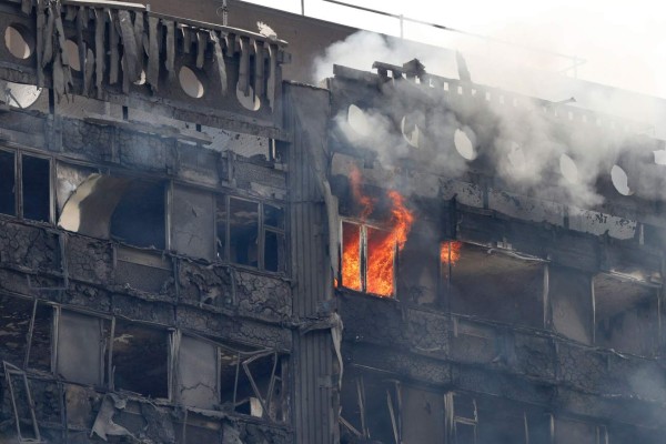 Flames and smoke continue to engulf Grenfell Tower, a residential block of flats in west London on June 14, 2017, as firefighters continue to control a fire that started in the early hours of the morning.At least six people were killed Wednesday when a massive fire tore through a London apartment block in the middle of the night, with witnesses reporting terrified people had leapt from the 24-storey tower. The tower was built as public housing and is located in a working-class but rapidly gentrifying part of the mostly wealthy Borough of Kensington and Chelsea. / AFP PHOTO / Adrian DENNIS