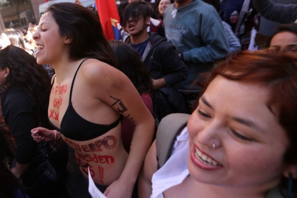 Pro-abortion activists celebrate outsidef the constitutional court in Santiago, on August 21, 2017. Chile's Constitutional Court Monday approved a measure to ease the country's strict abortion ban by decriminalizing the procedure in certain cases. / AFP PHOTO / CLAUDIO REYES