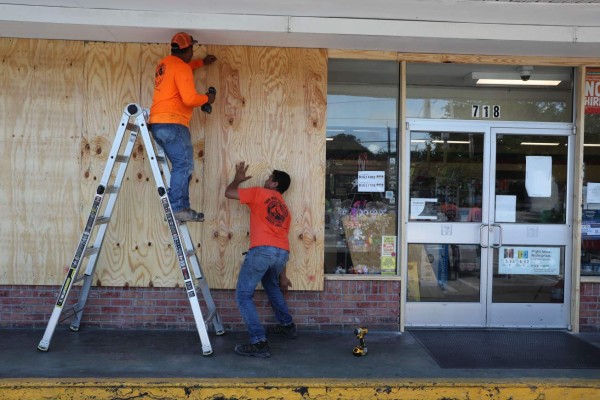 DELRAY BEACH, FLORIDA - AUGUST 31: Workers put plywood over the windows of a store as they prepare it in case Hurricane Dorian hits the area on August 31, 2019 in Delray Beach, Florida. Dorian was projected to make landfall along the Florida coast but now projections have it making a sharp turn to the north as it closes in on Florida. Joe Raedle/Getty Images/AFP== FOR NEWSPAPERS, INTERNET, TELCOS & TELEVISION USE ONLY ==