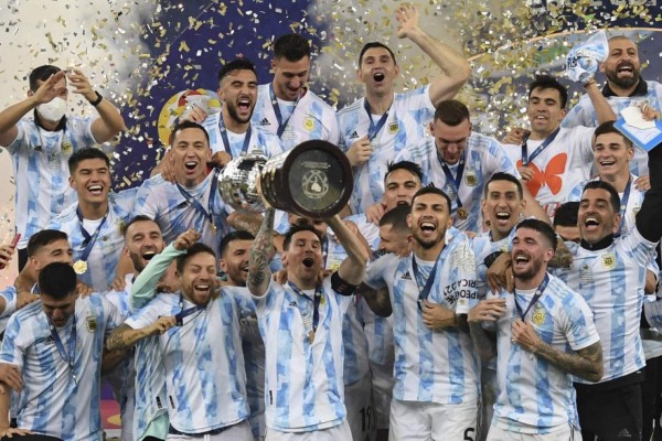 Argentina's Lionel Messi holds the trophy as he celebrates on the podium with teammates after winning the Conmebol 2021 Copa America football tournament final match against Brazil at Maracana Stadium in Rio de Janeiro, Brazil, on July 10, 2021. - Argentina won 1-0. (Photo by CARL DE SOUZA / AFP)