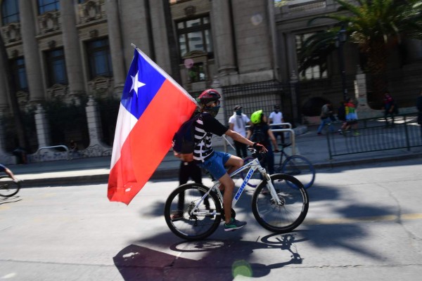 Demonstrators clash with riot police during protests in Santiago, on October 20, 2019. - Fresh clashes broke out in Chile's capital Santiago on Sunday after two people died when a supermarket was torched overnight as violent protests sparked by anger over economic conditions and social inequality raged into a third day. (Photo by Martin BERNETTI / AFP)