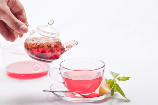 rose hip tea with mint leaves and lemon close-up white background.