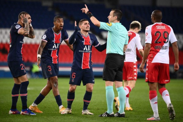 (LtoR) Paris Saint-Germain's French defender Layvin Kurzawa, Paris Saint-Germain's French defender Presnel Kimpembe and Paris Saint-Germain's Italian midfielder Marco Verratti argue with French referee Ruddy Buquet during the French L1 football match between Paris-Saint Germain (PSG) and AS Monaco FC at The Parc des Princes Stadium in Paris on February 21, 2021. (Photo by FRANCK FIFE / AFP)