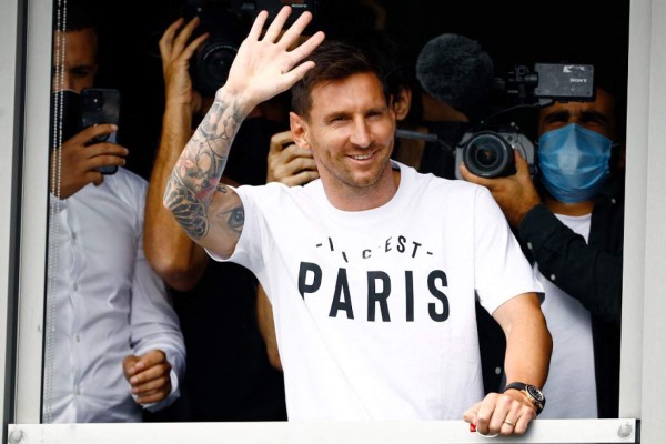 Argentinian football player Lionel Messi waves to supporters from a window after he landed on August 10, 2021 at Le Bourget airport, north of Paris, to become Paris Saint-Germain's new player following his departure from Barcelona, the club he has represented for the entirety of his 17-year professional career so far. - Asked by reporters at Barcelona's El Prat airport if the Argentine star would later on sign with the French club, Jorge Messi, the father and player's agent, said: 'Yes'. (Photo by Sameer Al-DOUMY / AFP)