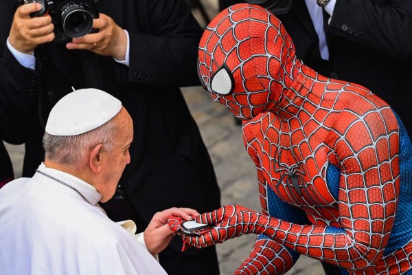 TOPSHOT - A man wearing a costume of the Spider-Man fantasy character, who performs in hospitals for sick children, hands a Spider-Man mask to Pope Francis as they meet at the end of the weekly general audience on June 23, 2021 at San Damaso courtyard in The Vatican. (Photo by Alberto PIZZOLI / AFP)