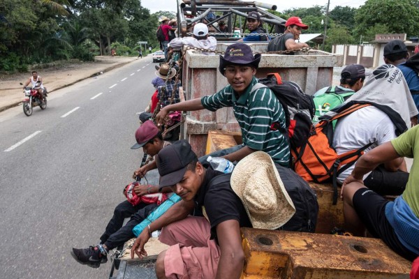 Migrants -mostly Hondurans- taking part in a caravan heading to the US, travel on a truck near Donaji, Oaxaca state on their way to Sayula and Acayucan, in Veracruz state, Mexico, on November 2, 2018. - President Donald Trump on Thursday warned that soldiers deployed to the Mexican border could shoot Central American migrants who throw stones at them while attempting to cross illegally. (Photo by Guillermo Arias / AFP)