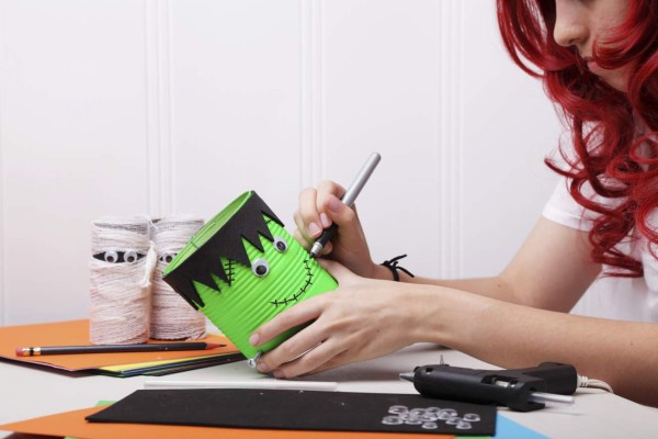 Beautiful red hair girl working on a Halloween craft project.