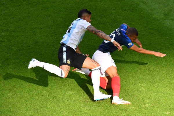 Argentina's defender Marcos Rojo (L) fouls France's forward Kylian Mbappe leading to a penalty during the Russia 2018 World Cup round of 16 football match between France and Argentina at the Kazan Arena in Kazan on June 30, 2018. / AFP PHOTO / SAEED KHAN / RESTRICTED TO EDITORIAL USE - NO MOBILE PUSH ALERTS/DOWNLOADS
