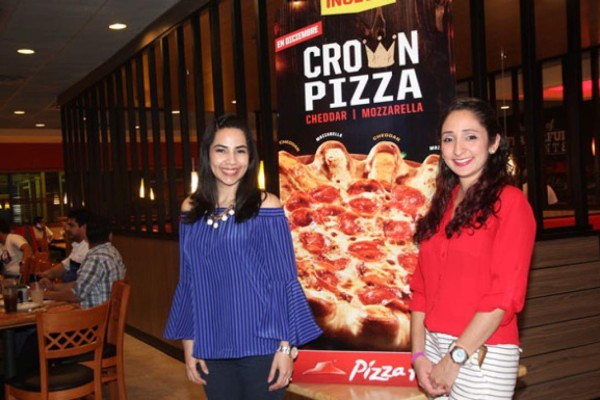 Erika Hernández y Giselle García en el lanzamiento de la pizza del mes llamada la Crown Pizza.