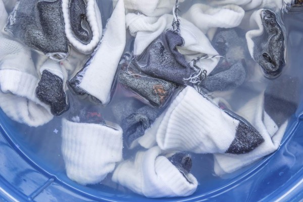 Dirty socks soaked wait in blue basin.