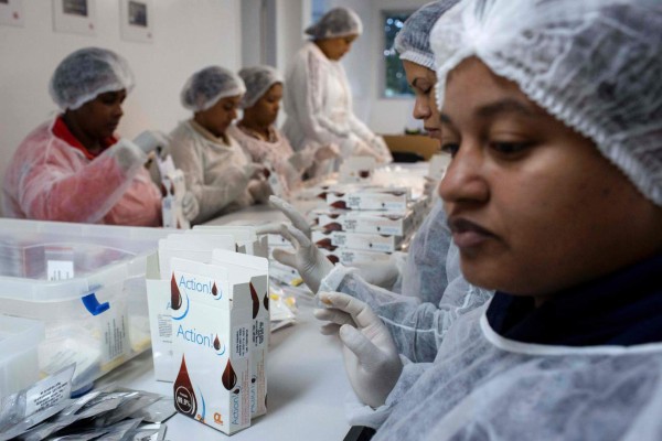 Women pack HIV self-test kits at OrangeLife factory in Rio de Janeiro, Brazil on July 07, 2017. Brazil started selling, for the first time, HIV detection tests in pharmacies nationwide. / AFP PHOTO / Mauro PIMENTEL / TO GO WITH AFP STORY