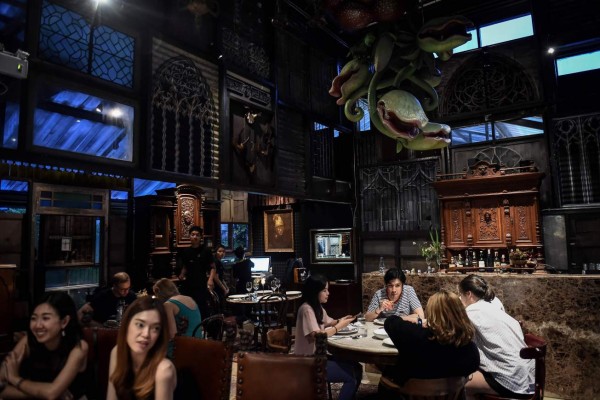 This photo taken on August 20, 2017 shows customers seated inside Insects in the Backyard, which says it offers the first insect-based fine-dining menu, in Bangkok.Bugs are creeping onto the menu of some of Bangkok's high-end restaurants as the capital's gourmands leap on the latest global food trend with a sustainable agenda. / AFP PHOTO / Lillian SUWANRUMPHA / TO GO WITH Thailand-food-insects-lifestyle, FEATURE by Sippichai KUNNUWONG and Delphine THOUVENOT