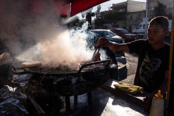 Joven hondureño trabaja en puesto de tacos mientras espera cruzar la frontera