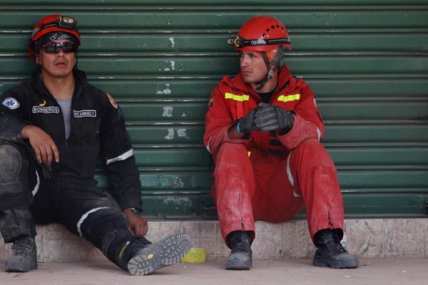 BOG129. PORTOVIEJO (ECUADOR), 19/04/2016.- Dos bomberos rescatistas hacen una pausa en las tareas de búsqueda de víctimas hoy, martes 19 de abril de 2016, , tras un fuerte sismo que sacudió al país, en Portoviejo (Ecuador). El centro de Portoviejo, una de las ciudades ecuatorianas más golpeadas por el terremoto de magnitud 7,8 que sacudió el país este sábado, es ahora una postal de escombros y polvo de los edificios derrumbados, donde aún quedan víctimas por rescatar. EFE/Christian Escobar Mora