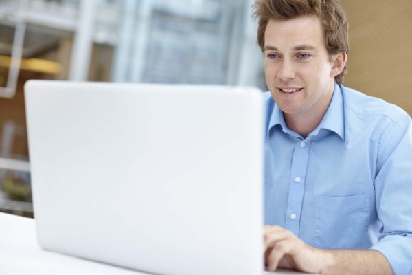 Young businessman using a laptop while sitting indoors