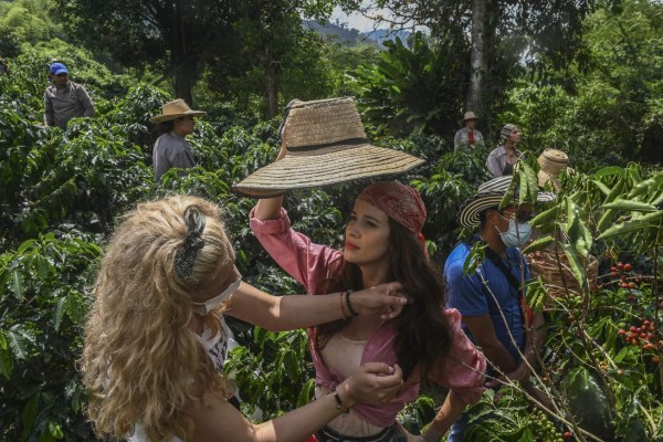 Colombian actress Laura Londono (C) is pictured backstage as a make up artist works on her during the production of a new version of the Colombian soap opera Cafe in the municipality of Chinchina, Caldas Department, Colombia, on December 8, 2020, amid the COVID-19 coronavirus pandemic. - Soap operas revive in Colombia, one of the major references of this industry in Latin America, after the paralysis by the pandemic. They are produced with asepsis, covid-19 tests, restriction in the capacity, masks, anti-fluid suits, adjusted budgets by the crisis and a permanent risk. According to the National Media Association (Asomedios), the confinement decreed by the government at the end of March forced RCN and its competitor Caracol to stop 38 productions. (Photo by Joaquin SARMIENTO / AFP)
