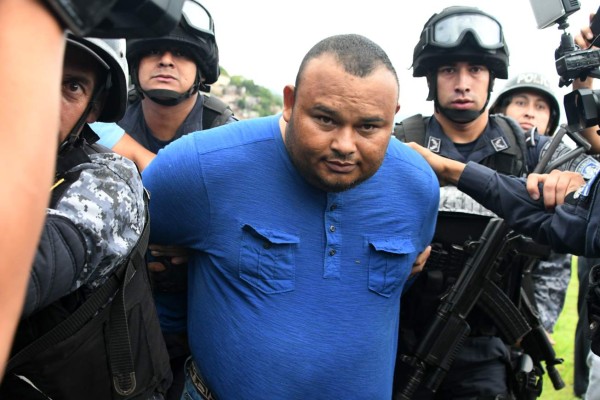 (FILES) In this file photo taken on June 14, 2017 Honduran alleged drug trafficker Noe Montes Bobadilla aka 'Tom' is escorted by agents of the Tigres special force of the National Police upon his arrival in Tegucigalpa. - On April 05, 2019 Honduran drug kingpin Montes Bobadilla,35, who had been extradited to the United States after his capture in Honduras in 2017, was sentenced by U.S. District Judge Liam O?Grady for the Eastern District of Virginia to 37 years in prison for trafficking thousands of kilograms of cocaine to the United States. (Photo by ORLANDO SIERRA / AFP)