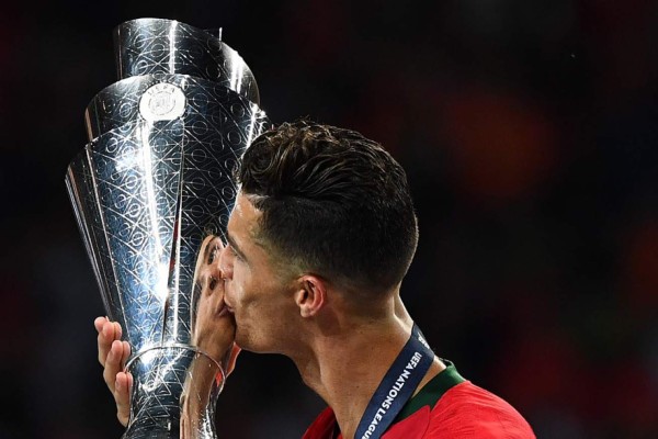 Portugal's forward Cristiano Ronaldo kisses the trophy after the UEFA Nations League final football match between Portugal and The Netherlands at the Dragao Stadium in Porto on June 9, 2019. (Photo by GABRIEL BOUYS / AFP)