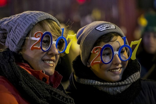 GRA157. MADRID, 31/12/2016.- Dos mujeres con gafas del 2017 en la Puerta del Sol con motivo de la celebración de las Campanadas de Año Nuevo. Una de las novedades en el apartado de seguridad es que este año la Policía ha colocado obstáculos, como maceteros, bolardos y vehículos pesados, para evitar atentados. En total, en el dispositivo de seguridad participan más de 800 efectivos entre los cuales 400 son policías nacionales y 400 policías municipales. EFE/Santi Donaire
