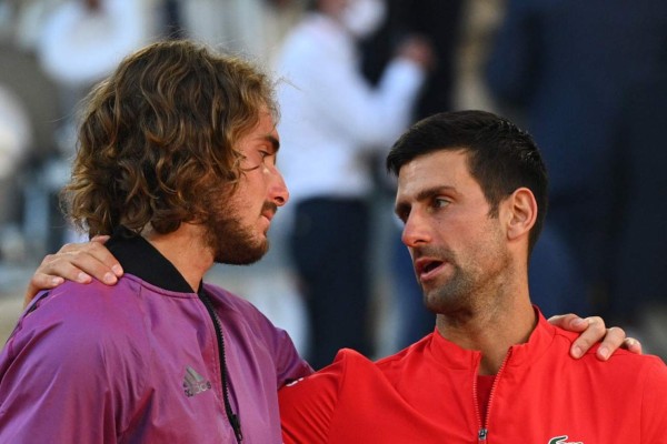 Winner Serbia's Novak Djokovic (R) and second-placed Greece's Stefanos Tsitsipas talk during the trophy ceremony, at the end of their men's final tennis match on Day 15 of The Roland Garros 2021 French Open tennis tournament in Paris on June 13, 2021. (Photo by Anne-Christine POUJOULAT / AFP)