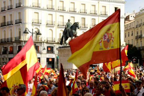 People hold Spanish flags during a demonstration against a referendum on independence for Catalonia, on October 01, 2017 in Madrid. / AFP PHOTO / JAVIER SORIANO