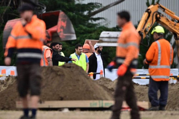 Representatives of the Muslim community and workers prepare gravesites for victims in Christchurch early on March 18, 2019, three days after a shooting incident that killed at least fifty people in mosques in the city. (Photo by Anthony WALLACE / AFP)