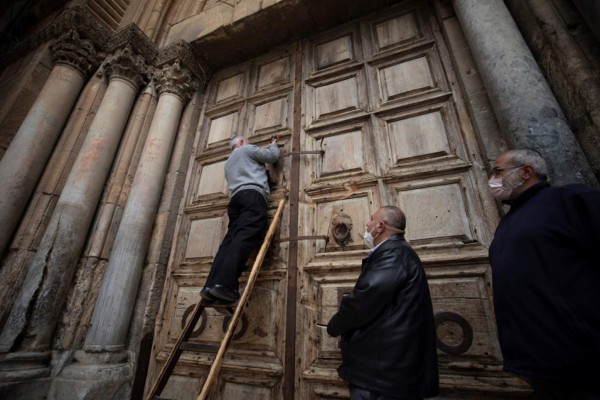 Jerusalem (Israel), 09/04/2020.- The guards of the Church of the Holy Sepulchre make final preparations for Easter holidays in the Old City of Jerusalem, Israel, 09 April 2020. Israel has imposed a lockdown to stem the spread of the Coronavirus which causes the Covid-19 disease. (Estados Unidos, Jerusalén) EFE/EPA/ATEF SAFADI