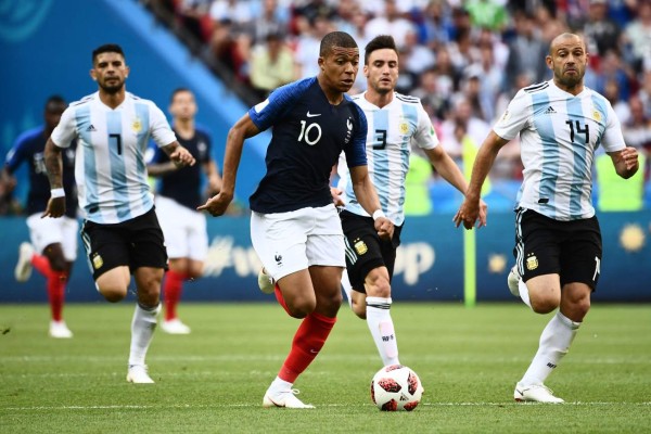 France's forward Kylian Mbappe (C) runs with the ball as he is marked by Argentina's midfielder Javier Mascherano (R) during the Russia 2018 World Cup round of 16 football match between France and Argentina at the Kazan Arena in Kazan on June 30, 2018. / AFP PHOTO / Jewel SAMAD / RESTRICTED TO EDITORIAL USE - NO MOBILE PUSH ALERTS/DOWNLOADS
