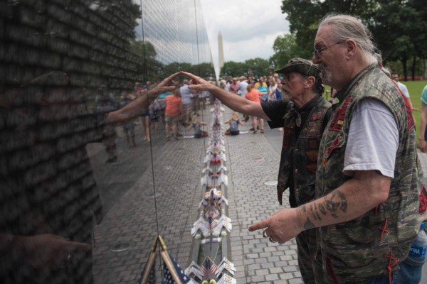 Vietnam War veterans search for names on the Vietnam War Memorial as thousands of bikers and military veterans take part in the 31st annual Rolling Thunder Ride for Freedom motorcycle parade in Washington DC, on May 27, 2018. Wearing bandanas, cowboy hats or gleaming helmets, tens of thousands of bikers descended on Washington Sunday to parade in honor of US soldiers missing in action in foreign wars, a now 30-year-old tradition known as 'Rolling Thunder.' / AFP PHOTO / Eric BARADAT