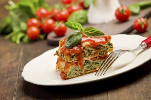 delicious homemade lasagne with ricotta cheese and spinach on wooden table