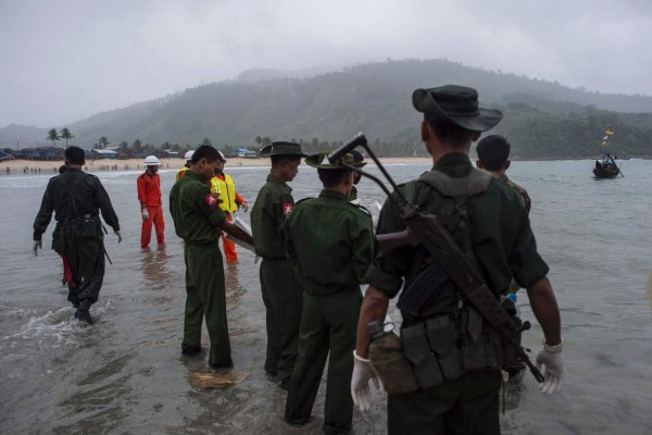 Myanmar military members prepare to unload the dead bodies from a small boat at Sanhlan village on June 8, 2017.Hundreds of people gathered solemnly on a beach in southern Myanmar awaiting news of their loved ones as rescuers worked to pull bodies from the Andaman Sea after a military plane crashed with more than 120 people on board. / AFP PHOTO / Ye Aung Thu