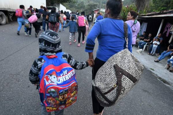 Honduran migrants heading to the United States with a second caravan walk after breaking through a police cordon in Agua Caliente, in the Honduras-Guatemala border on January 15, 2019. - Hundreds of Hondurans have set out on a trek to the United States, forming another caravan that US President Donald Trump cited Tuesday to justify building a wall on the border with Mexico. (Photo by ORLANDO SIERRA / AFP)