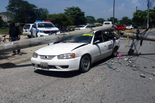 Se salvan de milagro tras caer poste sobre taxi