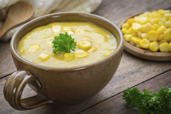 Corn soup in bowl and sweet corn on plate