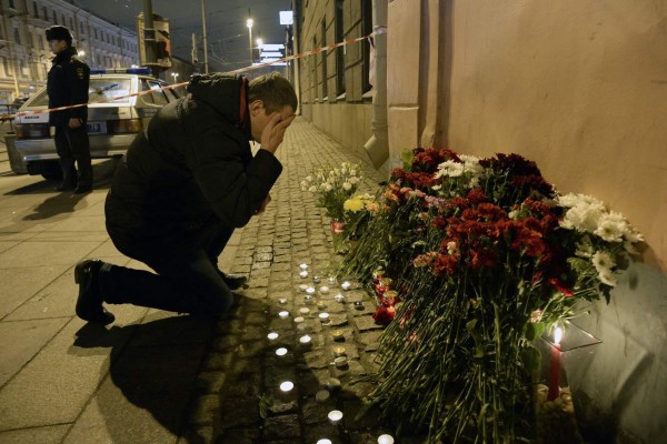 A man reacts as he places flowers in memory of victims of the blast in the Saint Petersburg metro outside Technological Institute station on April 3, 2017.Ten people were killed and several more injured Monday after an explosion rocked the metro system in Russia's second city Saint Petersburg, and authorities launched a probe into suspected 'act of terror'. / AFP PHOTO / Olga MALTSEVA