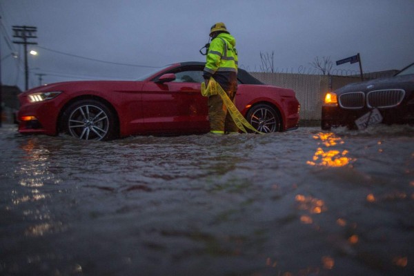 SUN VALLEY, CA - FEBRUARY 17: A firefighter checks on stalled cars in a flooded street as a powerful storm moves across Southern California on February 17, 2017 in Sun Valley, California. After years of severe drought, heavy winter rains have come to the state, and with them, the issuance of flash flood watches in Santa Barbara, Ventura and Los Angeles counties, and the evacuation of hundreds of residents from Duarte, California for fear of flash flooding from area denuded by a wildfire last year. David McNew/Getty Images/AFP== FOR NEWSPAPERS, INTERNET, TELCOS & TELEVISION USE ONLY ==