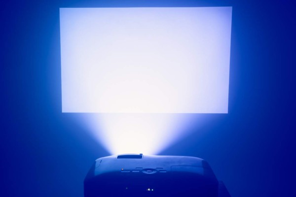 projector in action with illuminated blue screen and copy-space