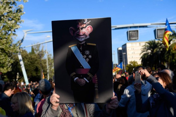 A demonstrator holds a placard depicting a caricature of King Felipe VI of Spain, during a pro-independence protest called 'neither King, nor fear' against the visit of the Spanish royal family in Barcelona, as part of the 10th anniversary of the Princess of Girona Foundation Awards (FPdGI), on November 4, 2019. - The streets of Barcelona and other Catalan cities are rocked by demonstrations for several days after Spain's Supreme Court on October 14 sentenced the nine leaders, mostly former members of the Catalan regional government, to prison terms of up to 13 years for sedition over a failed 2017 independence bid. (Photo by Josep LAGO / AFP)