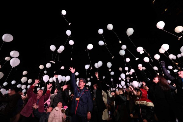 People release balloons, carrying their wishes, to celebrate the New Year at Prince Park Tower in the Japanese capital Tokyo on January 1, 2017. / AFP PHOTO / Behrouz MEHRI
