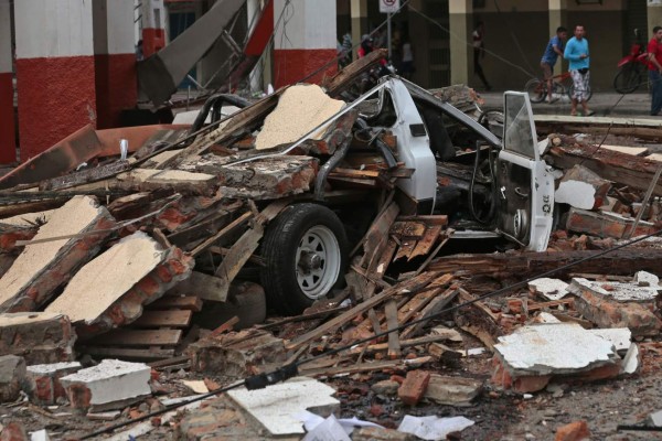 View of a vehicle squashed by rubble after a 7.8-magnitude quake in Portoviejo, Ecuador on April 17, 2016. At least 77 people were killed when a powerful earthquake struck Ecuador, destroying buildings and a bridge and sending terrified residents scrambling from their homes, authorities said Sunday. / AFP PHOTO / JUAN CEVALLOS