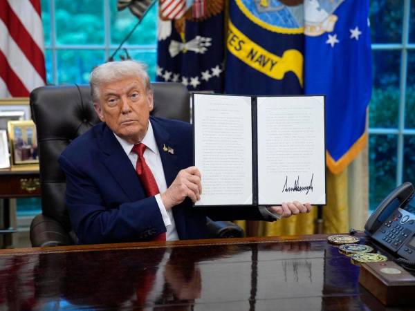 El presidente de Estados Unidos, Donald Trump, muestra una orden ejecutiva en la oficina oval de la Casa Blanca.