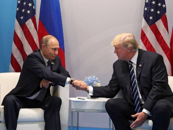El presidente estadounidense, Donald Trump, y el presidente ruso, Vladímir Putin, se estrechan la mano, en una imagen de archivo.