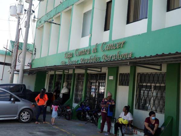 Un grupo de mujeres espera frente al edificio de la Liga Contra el Cáncer.