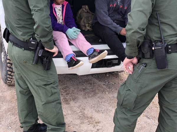 Fotografía de archivo donde aparecen dos agentes de la Patrulla Fronteriza mientras atienden a unos niños en un punto del área conocido como Quitobaquito, en la frontera de Arizona con México (EE.UU.).