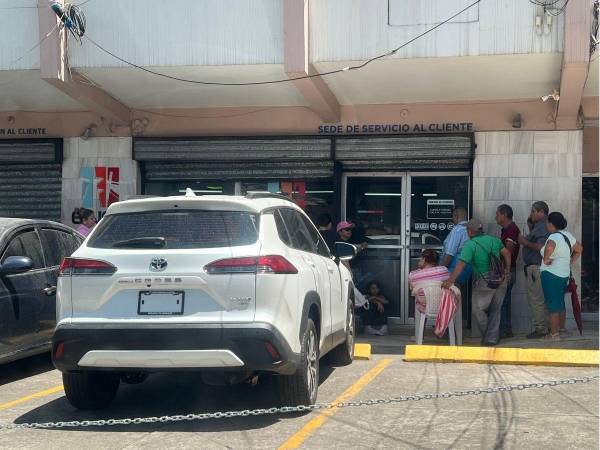 Abonados hacen fila frente a las oficinas de servicio al cliente de la Empresa Nacional de Energía Eléctrica (Enee), en el barrio Guamilito de San Pedro Sula, norte de Honduras.